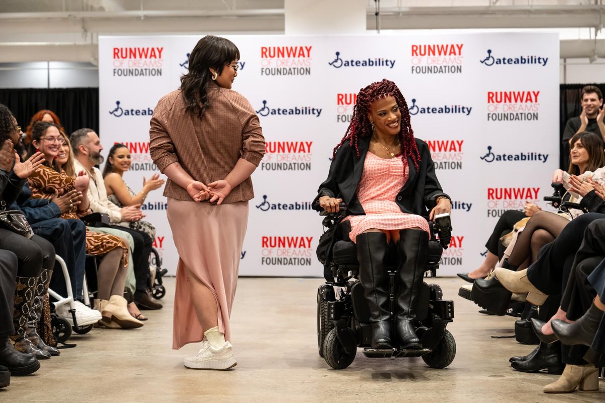 A Disabled LGBTQ+ model showcases Adaptive design at a ​Runway of Dreams Foundation fashion show.