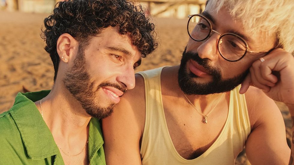 concerned gay men couple beach sunset