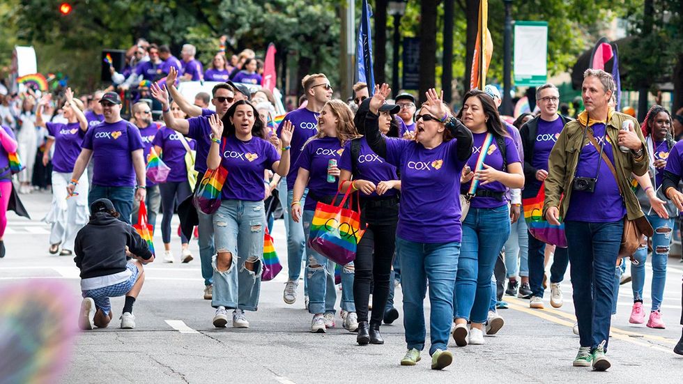 Cox Communications employees walk and wave to crowd LGBTQIA pride parade 2023 Atlanta GA