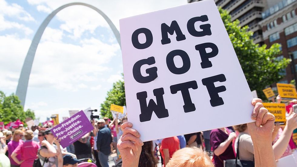 demonstrator holding sign omg gop wtf marching in support of Planned Parenthood St Louis Missouri arch in background