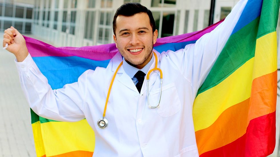 doctor holding rainbow flag lgbtq pride