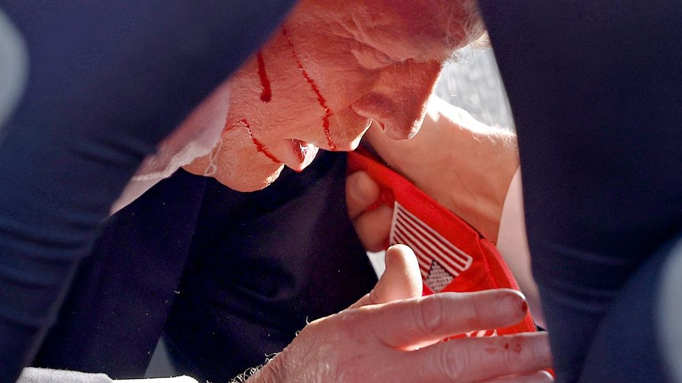 Donald Trump afraid injured bleeding on the floor shot at rally blood dripping down face on hand maga hat