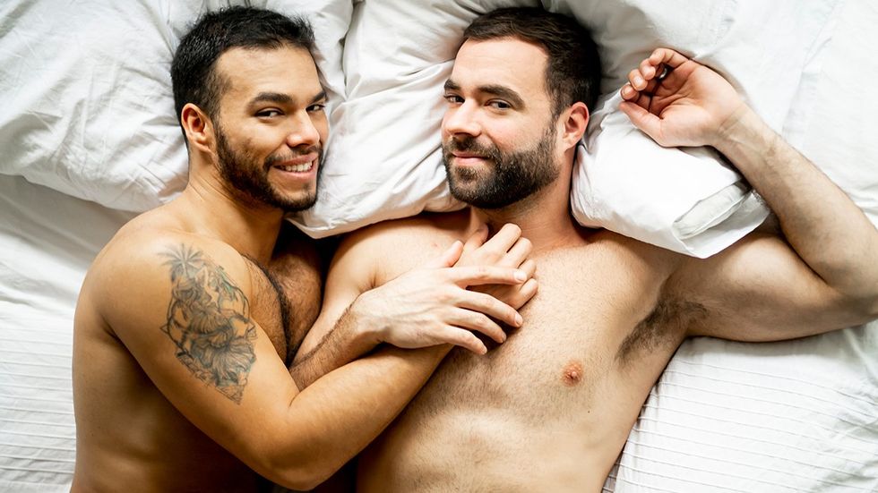 Handsome gay men couple on bed together