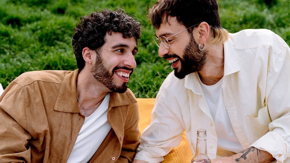 happy gay queer men picnic blanket grass