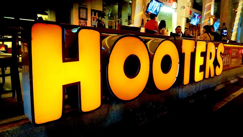 Hooters restaurant lighted logo bar in background