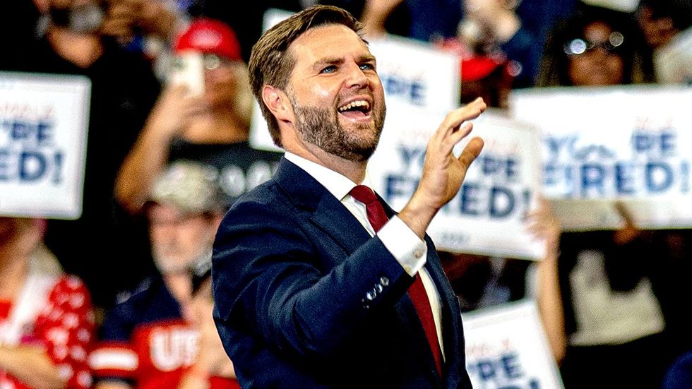 JD Vance in front of youre fired rally signs