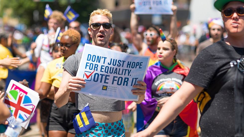 Man carries HRC sign that says Dont just hope for equality vote for it during the LGBTQ Pride Parade in Chicago Illinois