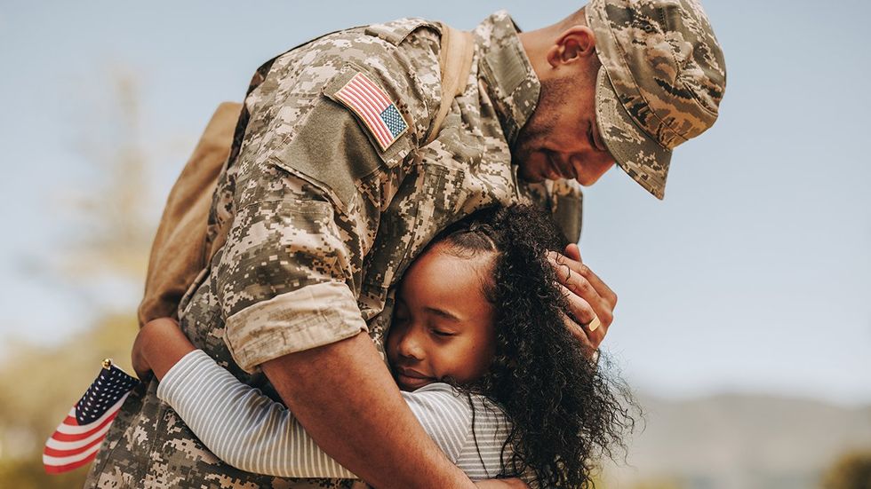 military parent hugging transgender child