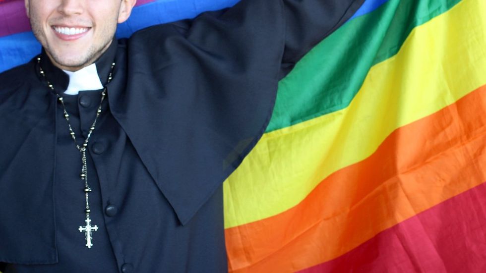 priest holding rainbow flag