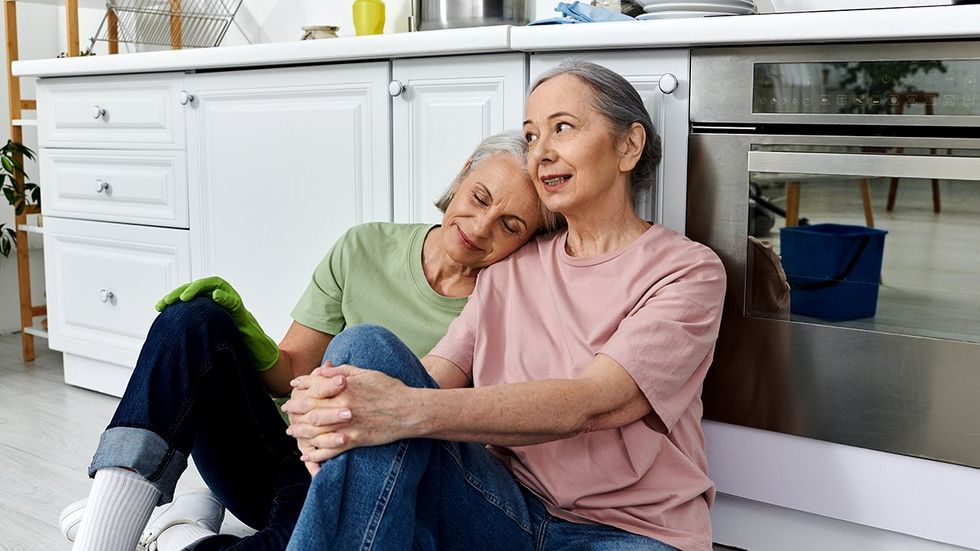 senior citizen lesbian couple taking break from cleaning house