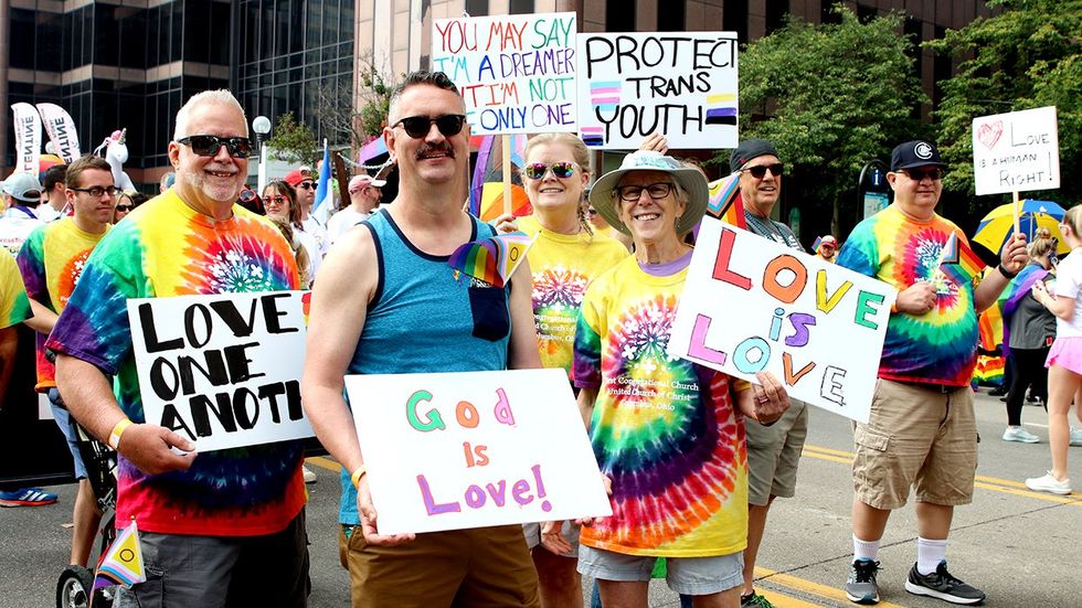 Stonewall LGBTQ Pride Festival Columbus Ohio Parade 2023 participants holding signs protect trans youth god is love