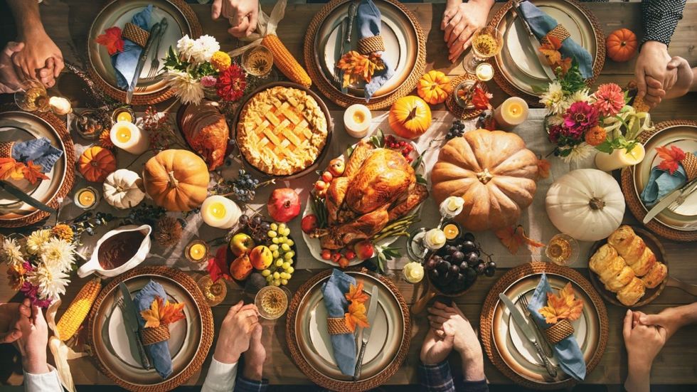 Thanksgiving dinner table with people holding hands