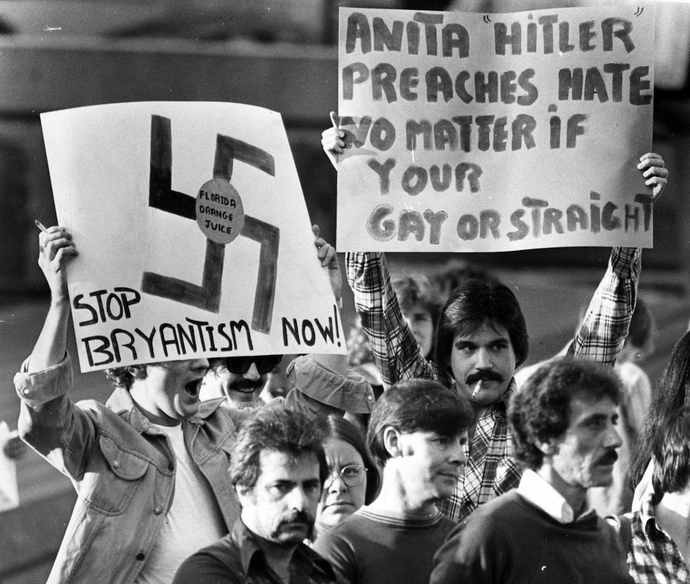 Protesters stand behind a sign during a demonstration in Copley Square as anti-gay activist Anita Bryant and Senate candidate Howard Phillips speak at a press conference at Copley Plaza in Boston, September 1, 1978. stand on