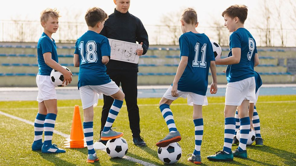 young teen boys soccer team coach field